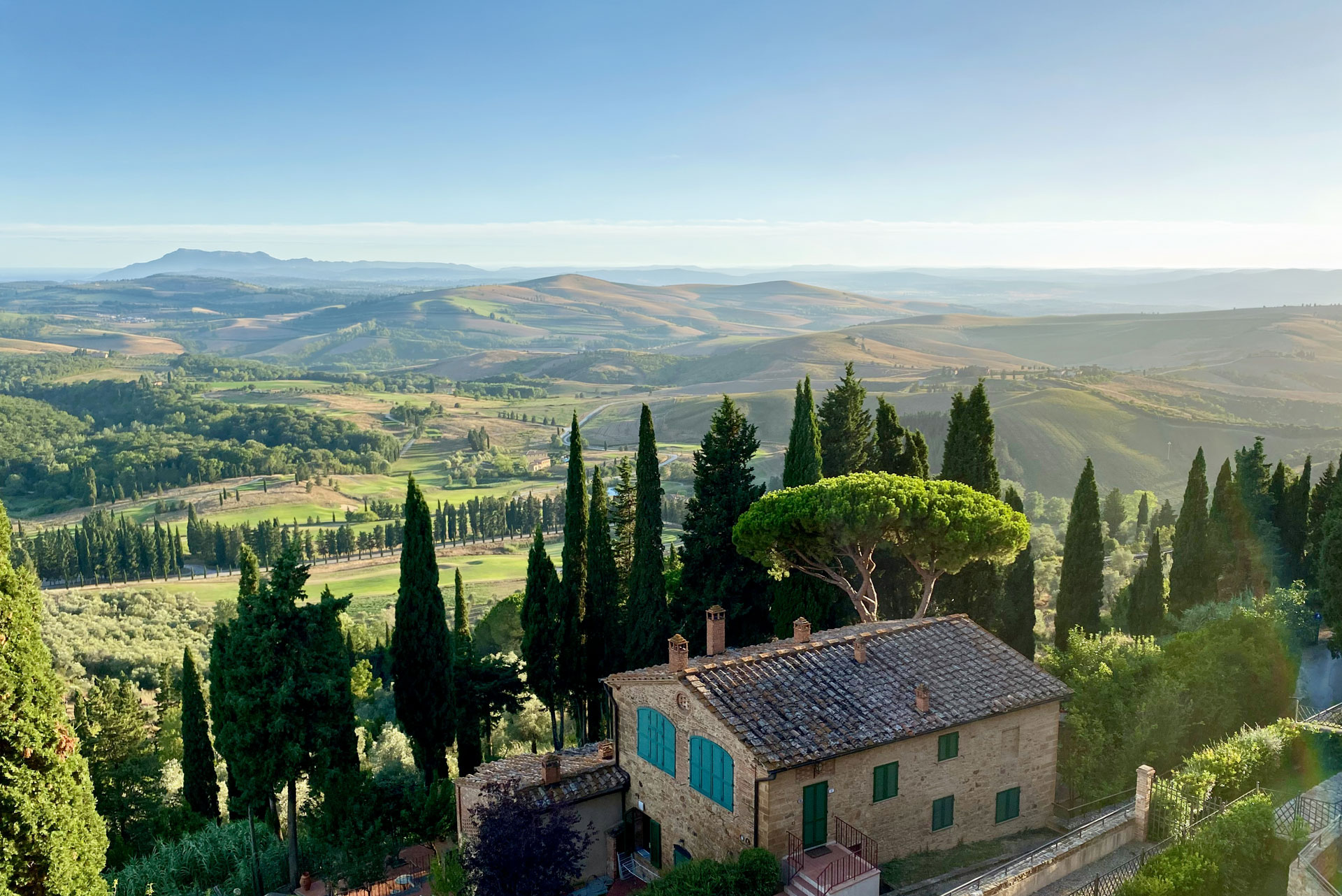 Casale toscano in pietra con cipressi e panorama collinare — gestione affitti brevi Toscana